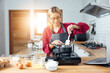 © vacancylizm - Beautiful young woman  is mixing batter, looking at camera and smiling while baking in kitchen at home ,decorating a cake of chocolate cake,cooking class, culinary, bakery, food and people concept