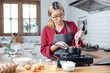 © vacancylizm - Beautiful young woman  is mixing batter, looking at camera and smiling while baking in kitchen at home ,decorating a cake of chocolate cake,cooking class, culinary, bakery, food and people concept