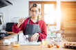 © vacancylizm - Beautiful young woman  is mixing batter, looking at camera and smiling while baking in kitchen at home ,decorating a cake of chocolate cake,cooking class, culinary, bakery, food and people concept