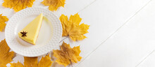 Fall Banner With Pumpkin Pie Piece On White Plate And Yellow Maple Leaves On White Wooden Table.