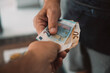 © simona - Close up of people exchanging cash banknote money. Concept of giving and taking euros. Economy and business. Present and loan back. Banking financial. Paying bills or credit action. One man give money