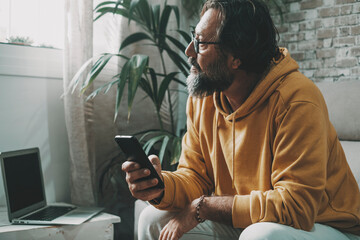 Man at home in technology connection leisure modern activity use mobile phone and laptop. One male people thinking and looking outside the window indoor. Problems and looking for idea concept life