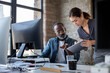 © ReeldealHD images - Coworkers working together on a digital tablet and a desktop computer