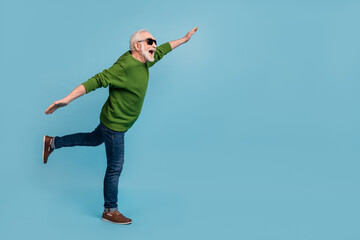 Full body profile photo of cheerful excited person arms flight empty space isolated on blue color background