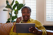 © ReeldealHD images - Senior African American woman watching entertainment on a digital tablet at home