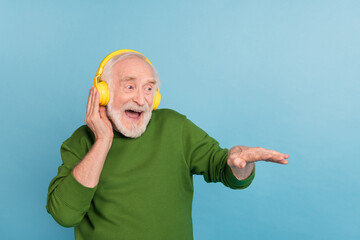 Wall Mural - Photo of overjoyed carefree funny granddad arm touch headphones enjoy sound isolated on blue color background