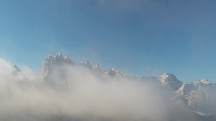 Wall Mural - Beautiful sunny day high up in the mountains in south tyrol with clear blue sky and some fog moving around and clearing in the end of the 4k timelapse, wider view with mountain pasture in foreground
