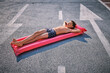 © VISTA by Westend61 - Shirtless boy lying on inflatable pool raft in parking lot