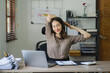 © Kritdanai - Portrait of a beautiful Asian woman looking at laptop screen while sitting at working desk in the office