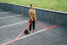Businesswoman Pulling Red Line At Parking Lot