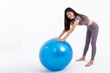 © Anatta_Tan - Portrait images of Asian attractive woman smile and wearing gym clothes Holding a blue exercise ball, On white background, to Exercise for health and weight loss concept.