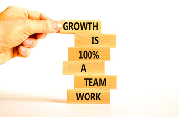 Wall Mural - Growth symbol. Concept words Growth is 100 percent a team work on wooden blocks on a beautiful white table white background. Businessman hand. Business motivational and growth is a team work concept.