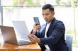© David - Take picture, Asian Businessman sitting at workplace desk and Taking Photograph Of Document In Office