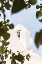 Selective Focus Of A White Church Bell Tower Seen Through The Leaves