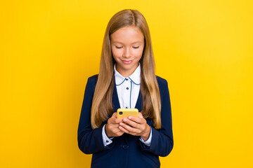 Wall Mural - Photo of pretty girl addicted user hand hold gadget telephone typing texting classmates friends isolated on yellow color background