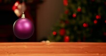 Animation Of Shiny Purple Christmas Bauble Over Defocussed Fairy Lights Flashing On Tree