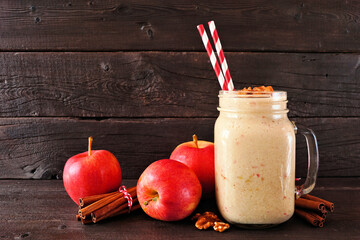 Wall Mural - apple pie smoothie in a mason jar with walnuts and cinnamon. side view scene on a dark wood backgrou