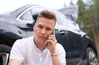 © Евгений Шемякин - Sad upset guy driver sitiing near broken car after road accident, crash, calling emergency on cell mobile phone talking on smartphone. Young desperate man got into accident