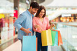© Prostock-studio - Excited Family Couple Looking Into Shopper Bags Shopping In Mall
