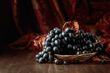 Poster - Blue grapes on an old wooden table.