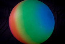 Balloon In Bright Colors Of The Rainbow On A Black Background