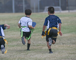 Wall Mural - Young boys playing in a game of flag football