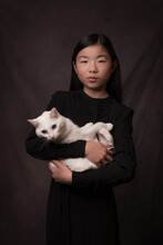 Asian Girl Holding White Cat In Classic Painterly Studio Portrait