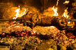 cooking suckling pig over a open fire at night, roast suckling pig, suckling pig on the spit