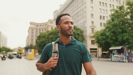 Young man tourist walks along the square of the old city, considers the sights