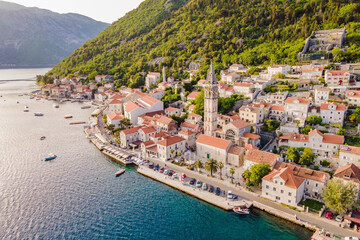 Wall Mural - Scenic panorama view of the historic town of Perast at famous Bay of Kotor with blooming flowers on a beautiful sunny day with blue sky and clouds in summer, Montenegro, southern Europe Portrait of a