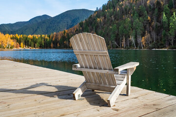 comfortable wooden sun lounger against the backdrop of colorful mountains with emerald lake