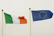 © mark_gusev - Waving flag of Euro Union and Republic of Ireland on grey sky background.