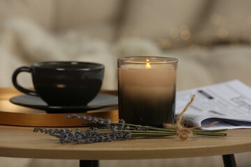 Sticker - Beautiful candle, lavender, newspaper and cup on round wooden table in living room, closeup