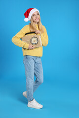 Wall Mural - Happy woman with vintage radio on blue background. Christmas music