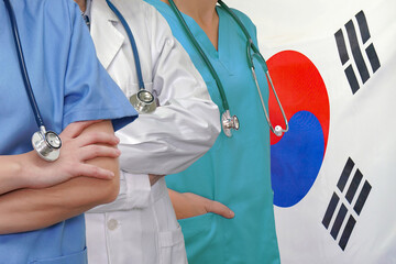 Wall Mural - Three Doctors with stethoscope in standing on South Korea flag background. Close-up medical team. Group of doctors and nurses. Innovative technologies in medical development in South Korea