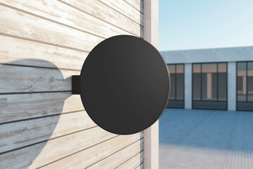 Wall Mural - Empty round black stopper on wooden building. Bright city with sunlight background. Ad, pub, cafe, or restaurant banner. Mock up, 3D Rendering.