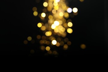 Wall Mural - blurred view of golden lights on black background. bokeh effect