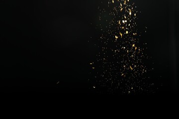 Wall Mural - shiny golden glitter falling down on black background. bokeh effect