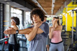 © NDABCREATIVITY - Multiethnic group of people training in a gym. Trainer and sportive fit persons exercising