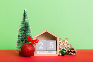 Wall Mural - 25 december. Christmas composition on colored background with a wooden calendar, with a gift box, toys, bauble copy space