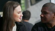 © Marco - Diverse couple seated at coffee shop listening in conversation. Two people at restaurant interaction
