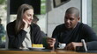 © Marco - Happy couple seated at coffee shop. Diverse man and woman at cafe place. Two people at restaurant