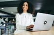 © Jacob Lund - Pensive businesswoman working on a laptop in a co-working office