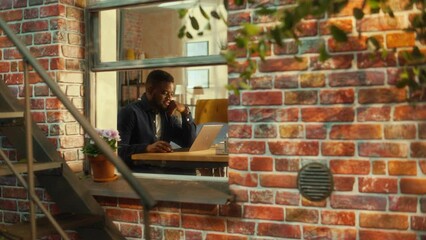 Aufkleber - Portrait of a Young Black Male Sitting at a Desk, Thinking, Working on Laptop Computer. Creative Freelance Writer Doing Remote Work from Home Office. Stylish Apartment Shot from Window.