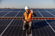 © dusanpetkovic1 - A happy worker with drill in his hands is showing okay gesture while couching next to the solar panels.