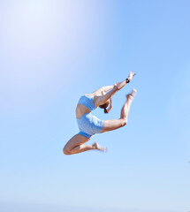 Wall Mural - Fitness, jumping and sky with a sports woman mid air outdoor against a clear blue background during summer. Workout, exercise and training with a female athlete leaping for health and wellness