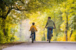 © Maria Moroz - Happy father and daughter ride bicycles in autumn park on sunny day.