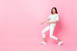 © deagreez - Full length photo of cheerful crazy girl dressed striped stylish clothes hold rope empty space rejoice isolated on pink color background