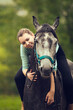 Young girl sits astride a grey horse . Girl rider. Portrait close up