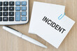© Volha - Text INCIDENT on a card on a paperclip on a wooden table next to a pen and calculator